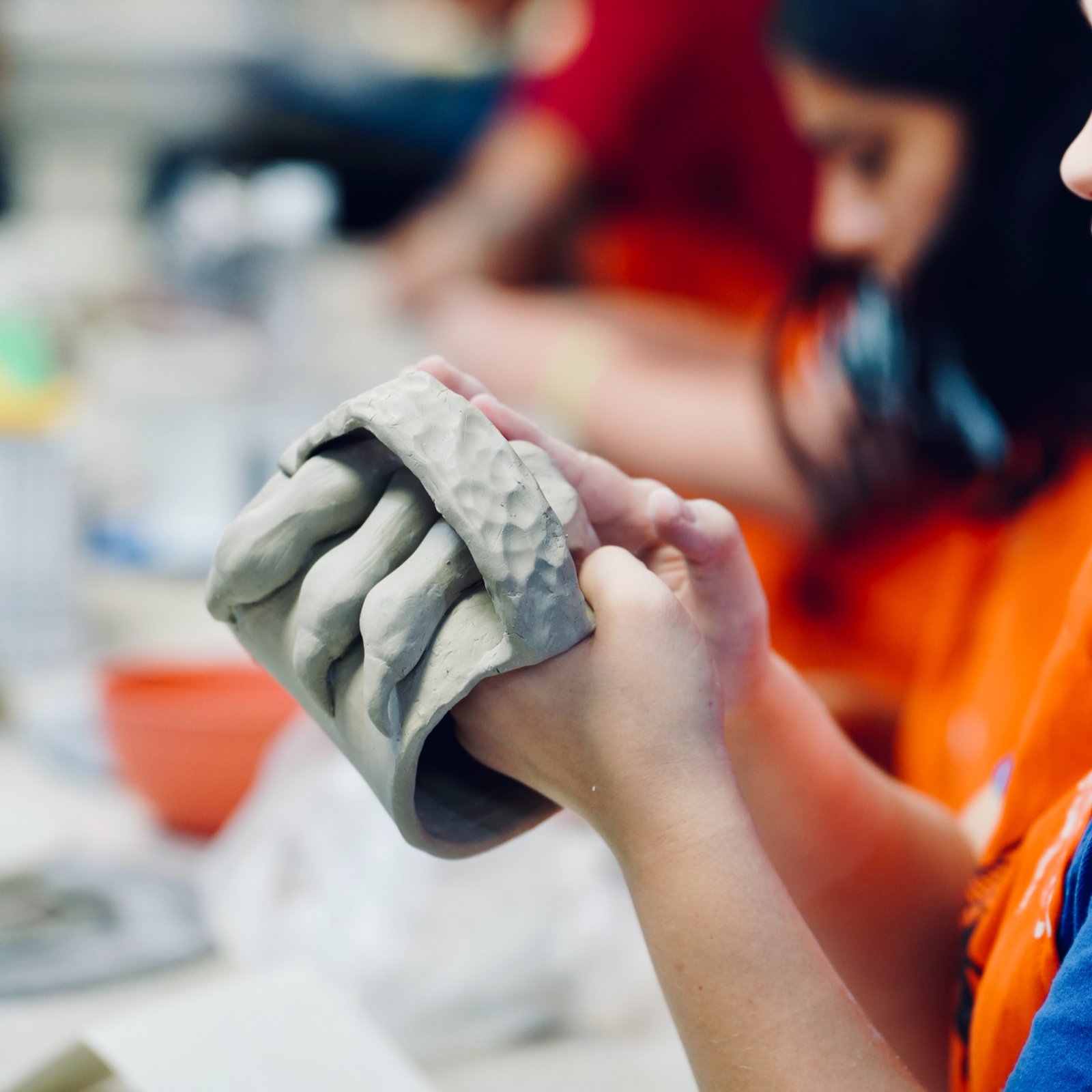 Close-up view of a potter shaping clay on a wheel